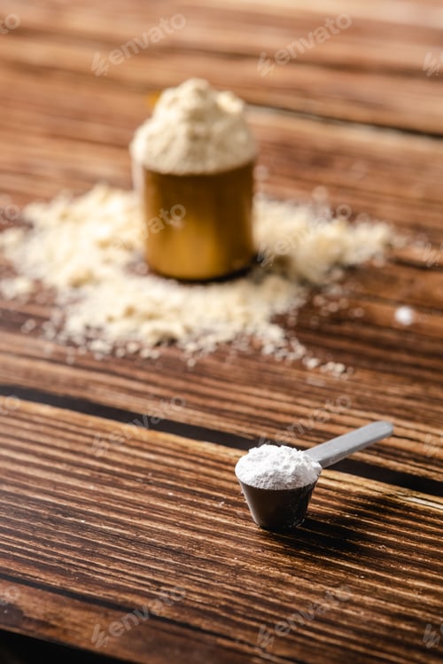 Preview: Sports supplements on a wood table background. Vertical composition with protein and creatine.