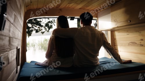 Preview: Couple relaxing in camper van looking at lake view