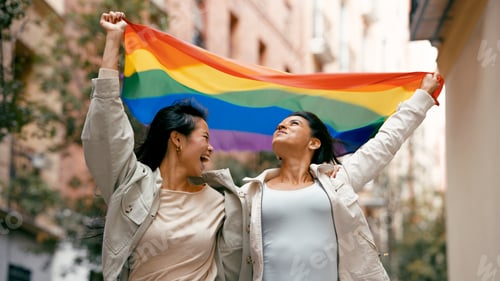 Preview: Two women celebrating pride holding rainbow flag