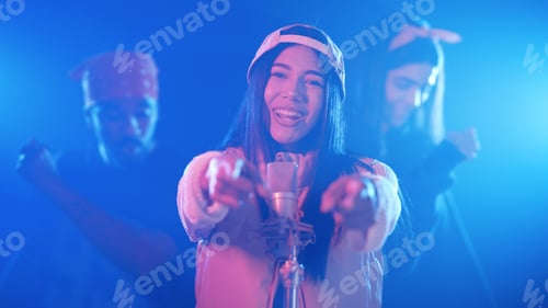 Preview: Female singer performing on stage with dancers