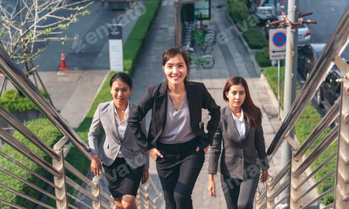 Preview: Team leadership businesswoman walking together on street city life. Group of business people team le