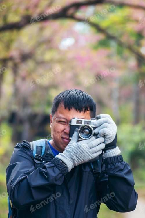 Preview: Vertical image Asian man use professional digital camera take a photo. Smiling male photographer loo