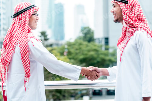 Preview: Arab Businessman Muslim dress shaking hands together. Muslim Men Teamwork business partner handshake