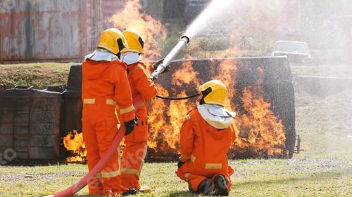 Preview: Firefighter fighting with flame using fire hose chemical water foam spray engine. Fireman wear hard