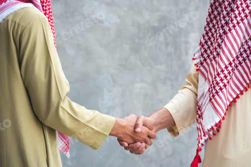Preview: Arab Businessman shaking hands together. Teamwork business partner wear Muslim dress Shake Hands wit