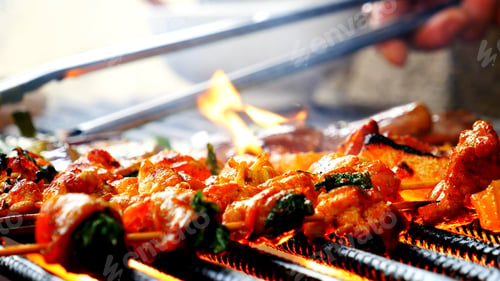 Preview: BBQ Barbecue grilled meat stick on fire flame with hot charcoal cooking outside. Beef grilling picni