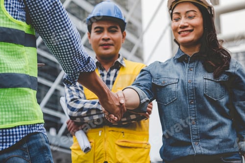 Preview: Civil Construction engineer teams shaking hands together wear work helmets worker on construction si