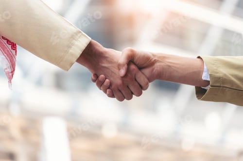 Preview: Arab Businessman shaking hands together. Teamwork business partner wear Muslim dress Shake Hands wit