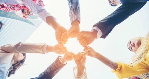 Preview: Multiethnic group of young teamwork standing hands together