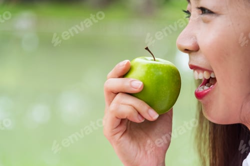Preview: young asian woman eating Apple Healthy. Girl workout holding organic apple fruit healthy lifestyle.