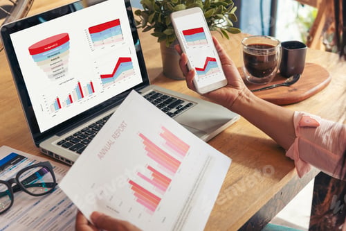 Preview: Woman working at home office desk using laptop business financial document chart and graph on wooden