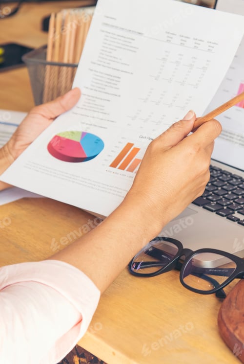 Preview: Vertical Businesswoman reading financial graph charts business info with computer laptop. Vertical h