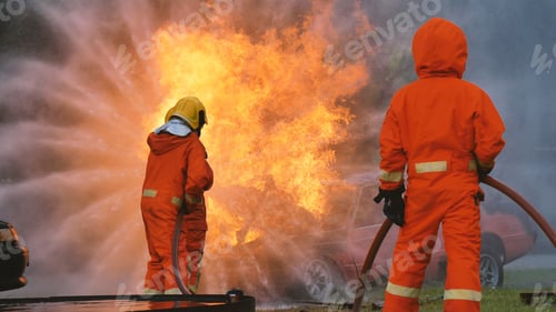 Preview: Firefighter fighting with flame using fire hose chemical water foam spray engine. Fireman wear hard