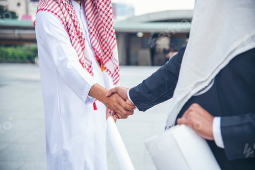 Preview: Arab Businessman Muslim dress shaking hands together. Muslim Men Teamwork business partner handshake