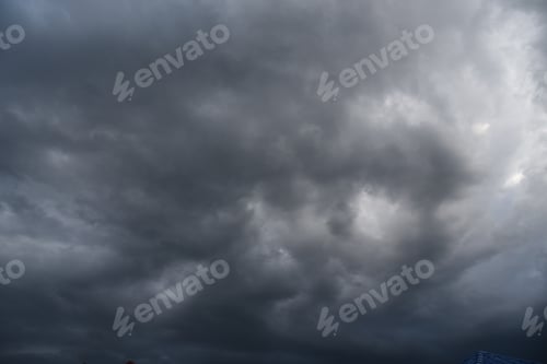 Preview: Dramatic dark storm thundercloud rain clouds on black sky background. Dark thunderstorm clouds rainn