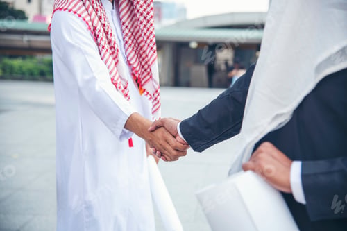 Preview: Arab Businessman Muslim dress shaking hands together. Muslim Men Teamwork business partner handshake