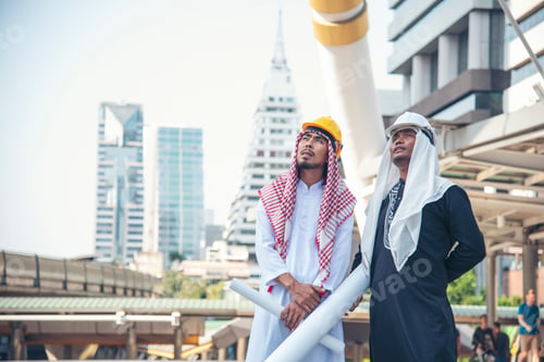 Preview: Arab civil engineer construction project hold blueprint, pointing at construction site modern muslim