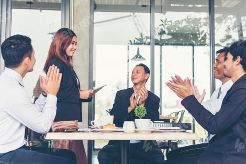 Preview: Business Partners clapping hands to a success business woman after complete a deal.