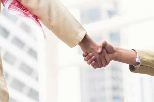 Preview: Arab Businessman shaking hands together. Teamwork business partner wear Muslim dress Shake Hands wit