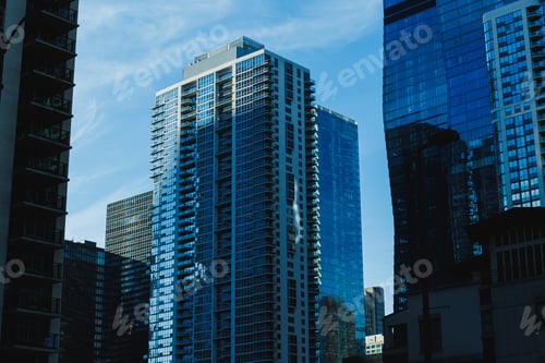 Preview: City skyline under blue sky with modern buildings in the afternoon light showing reflections and