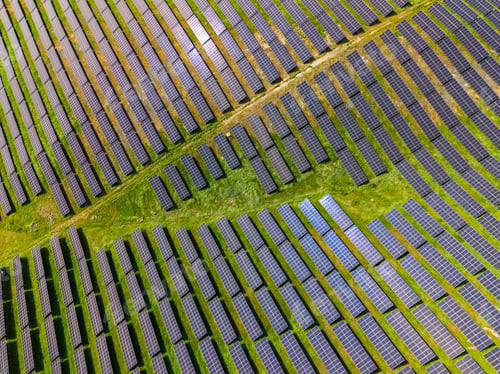 Preview: Solar panels cover a large field in a rural area during a bright sunny day showcasing renewable