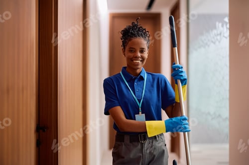 Preview: Black female commercial cleaner at work looking at camera.
