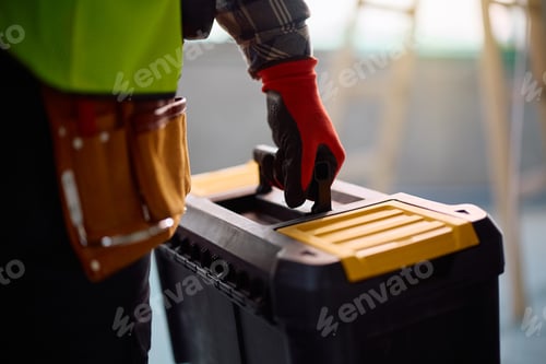 Preview: Close up of construction site worker with a toolbox at renovating home.