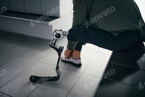 Preview: Close up sportsman with prosthetic leg getting ready for gym workout.