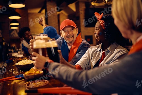 Preview: Happy fans toasting with beer while watching sports match in a pub.