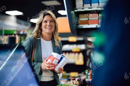 Preview: Happy woman communicating with cashier at supermarket checkout.