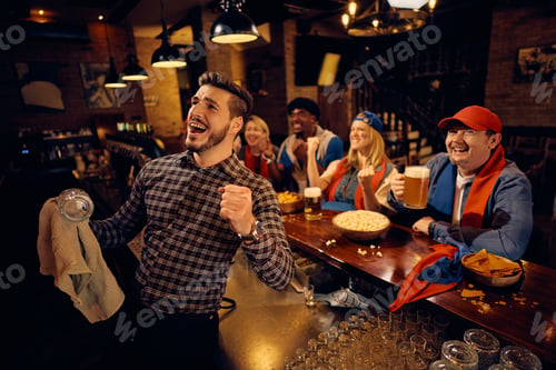 Preview: Happy barmen and sports fans cheering while watching match on TV in pub.