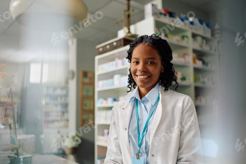 Preview: Happy African American female pharmacist at work looking at camera.