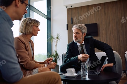 Preview: Mature financial advisor talking to a couple during the meeting.