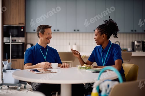 Preview: Happy professional cleaners talking while having lunch break at work.
