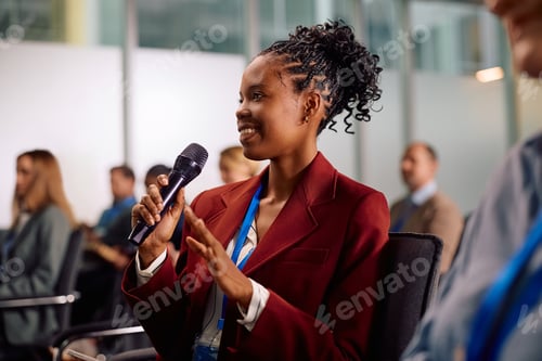 Preview: Happy black businesswoman talking from the audience while attending an education event.