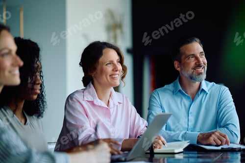 Preview: Happy businesswoman and her colleagues during a meeting in the office.