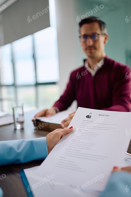 Preview: Close up of HR manager reviewing CV of a job applicant in the office.