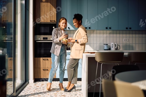Aperçu: Happy female entrepreneurs using smart phone on a break in office kitchen.