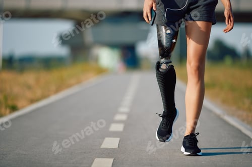Preview: Unrecognizable sportswoman with artificial leg taking a walk outdoors.