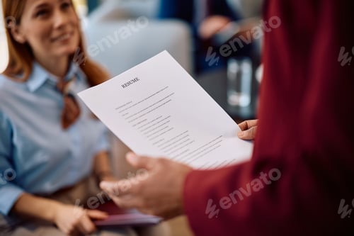 Preview: Close up of human resource manager with candidate's CV in the office.