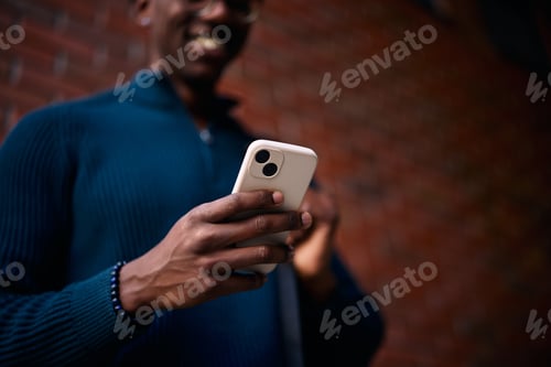 Preview: Close up of black man surfing the net on smart phone.