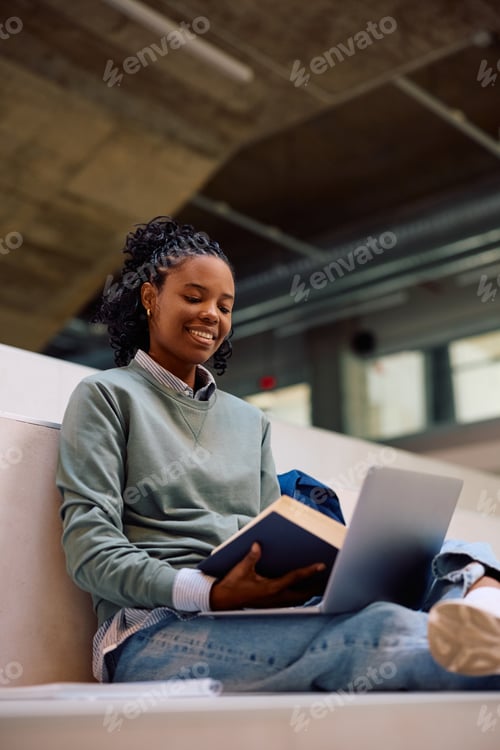 Preview: Happy black female student learning at the university.