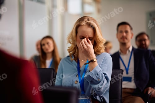 Preview: Businesswoman having a headache during a seminar in conference room.