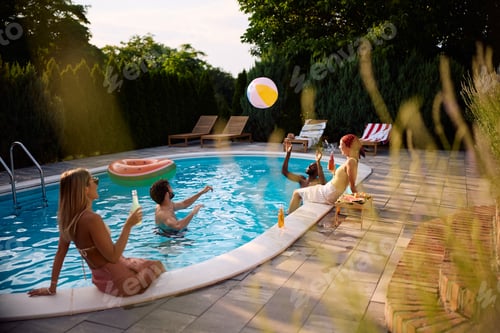 Preview: Playful friends having fun during summer pool party.