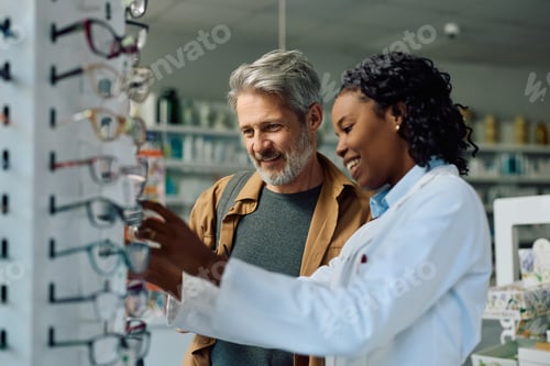 Preview: Happy black ophthalmologist assisting her customer in drugstore.