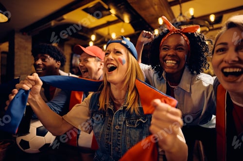 Preview: Passionate soccer supporters watching championship game on TV in a bar.