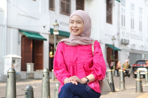 Preview: asian muslim woman sitting on the side of the street at Kota Lama or old town city, Semarang, Indone