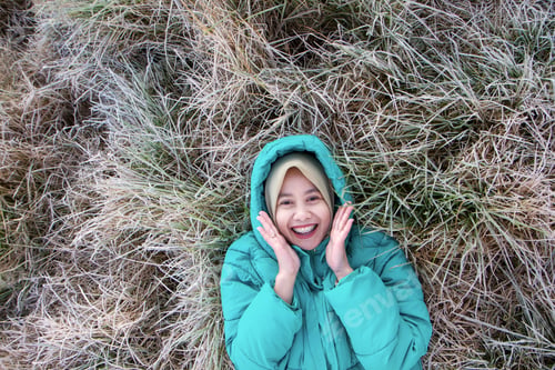 Preview: Happy Muslim Woman on Frost Covered Grass During Cold Morning in Dieng