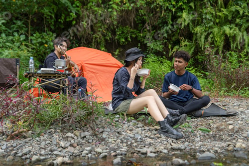 Preview: Campers Eating Together Beside Tent During Outdoor Adventure
