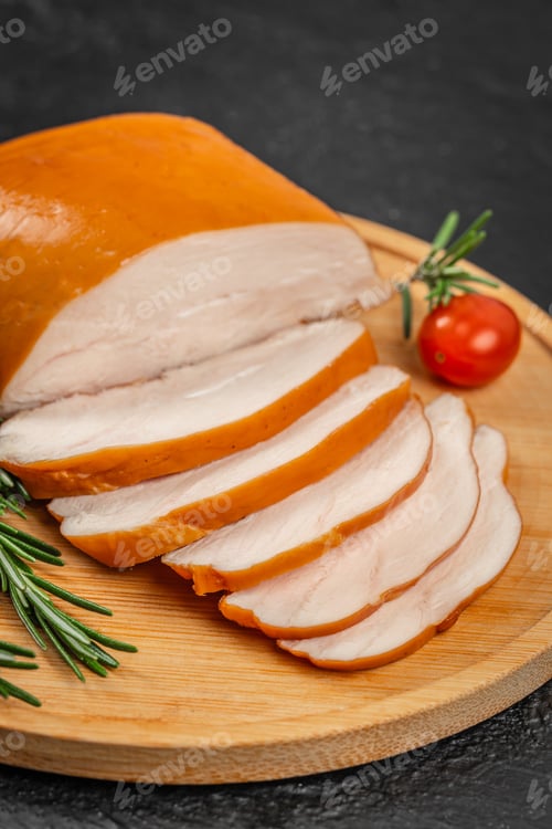 Preview: Sliced smoked chicken breast on wooden board with rosemary